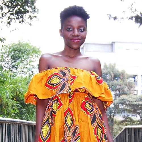 Florence Otieno in an off the shoulder brightly colored dress