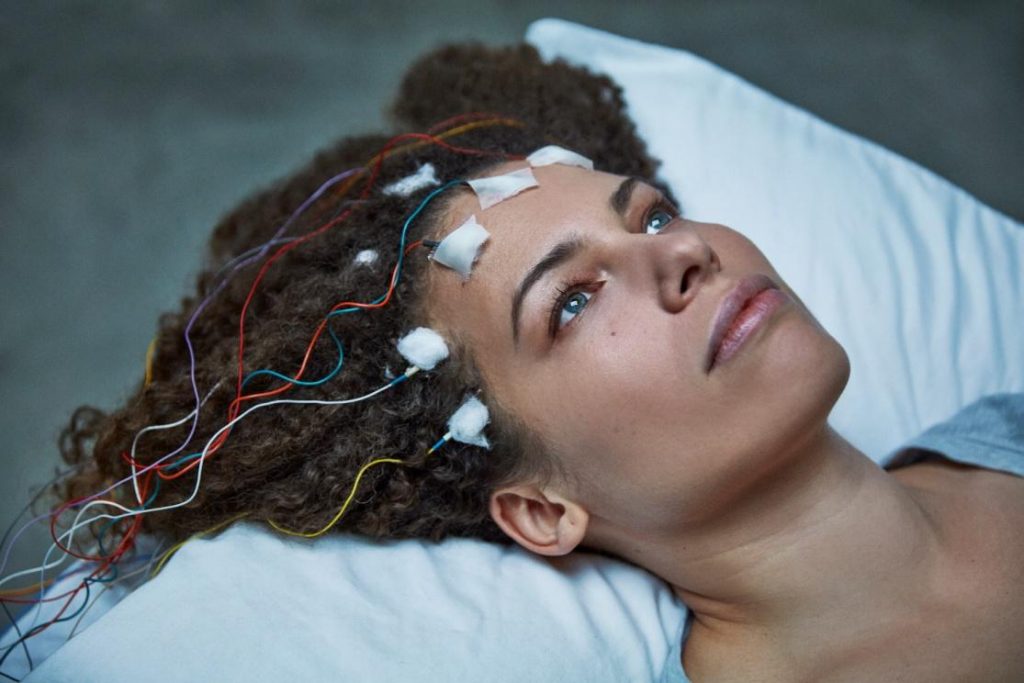 woman's head on pillow with transmitters attached to forehead